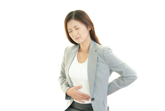 お腹の違和感を感じる女性